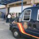Vehículo policial en la entrada del aeropuerto de Melilla con personas en el fondo.