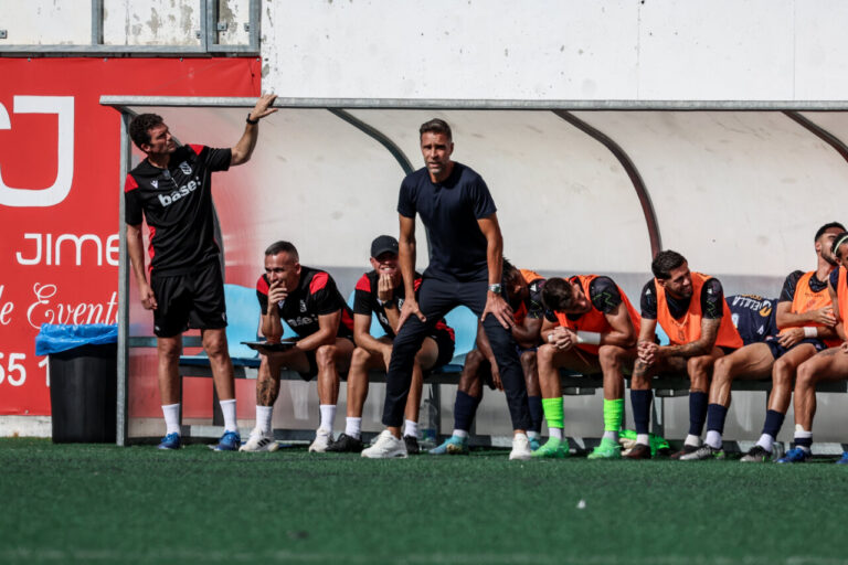 Entrenador Alberto Cifuentes en el banquillo durante un partido de fútbol