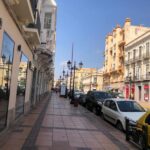 Vista de una avenida en Melilla con edificios y coches aparcados