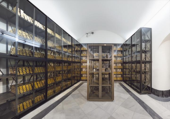 Interior del Banco de España con estanterías de oro y diseño moderno.