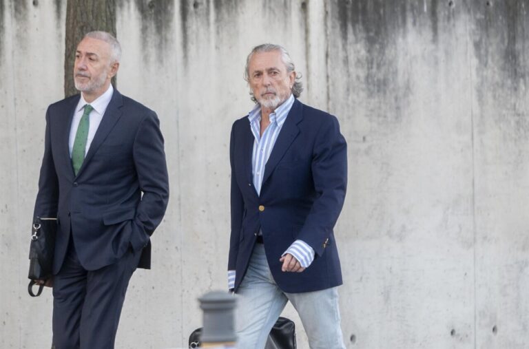 Dos hombres caminando juntos hacia un juicio sobre corrupción.