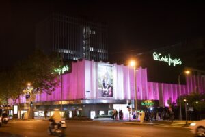 Fachada iluminada de El Corte Inglés por la noche en color rosa