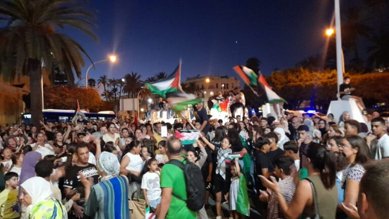 Multitud de personas en Melilla sosteniendo banderas palestinas durante una concentración