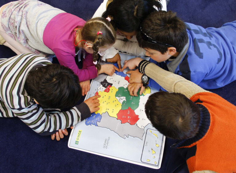 Niños interactuando con un mapa en un entorno educativo