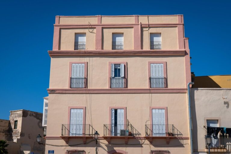 Fachadas de edificios en Melilla La Vieja bajo un cielo azul.