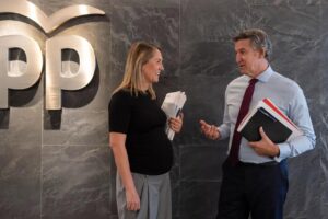 Alberto Núñez Feijóo conversando con una mujer en un entorno político.