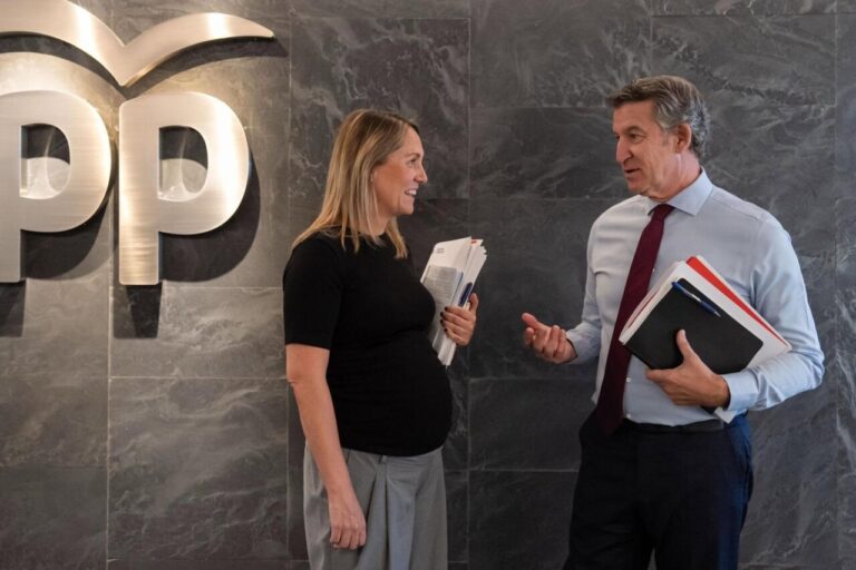 Alberto Núñez Feijóo conversando con una mujer en un entorno político.