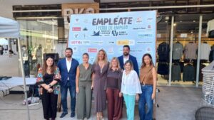 Grupo de personas en la I Feria Empresarial de Melilla frente a un cartel