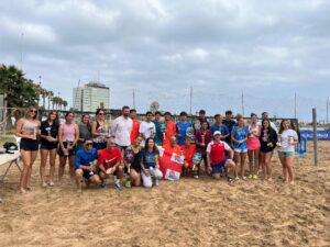 Grupo de personas en la playa tras un torneo de tenis playa