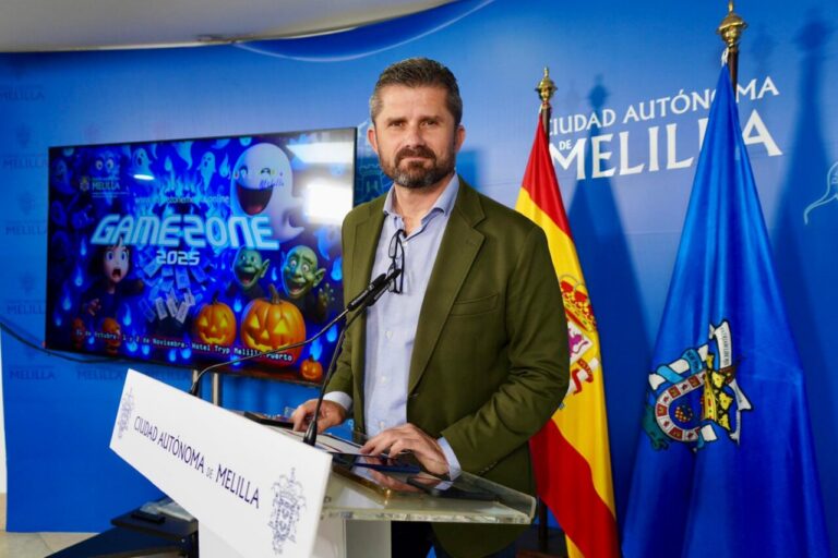 Presentador en evento Game Zone con fondo de pantallas y banderas