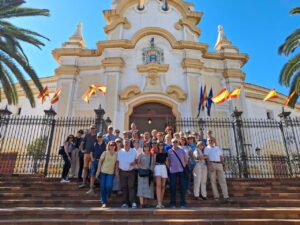 Grupo de turistas en la Plaza de Toros de Melilla con palmeras al fondo.