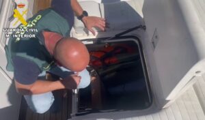 Agente de la Guardia Civil revisando un compartimento en una embarcación