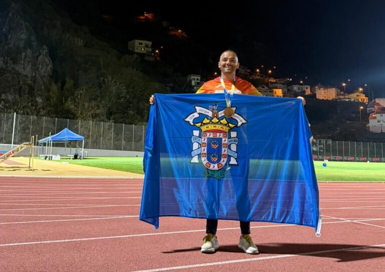 Hadriel Mehamed González sosteniendo la bandera de Melilla con medalla de bronce