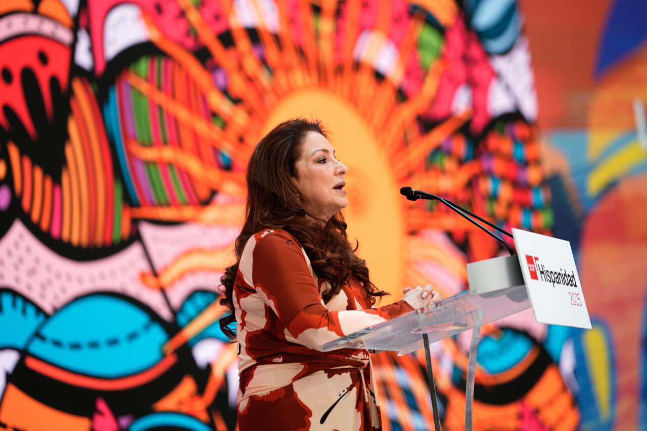 Mujer hablando en un evento del festival Hispanidad 2025 en Madrid.