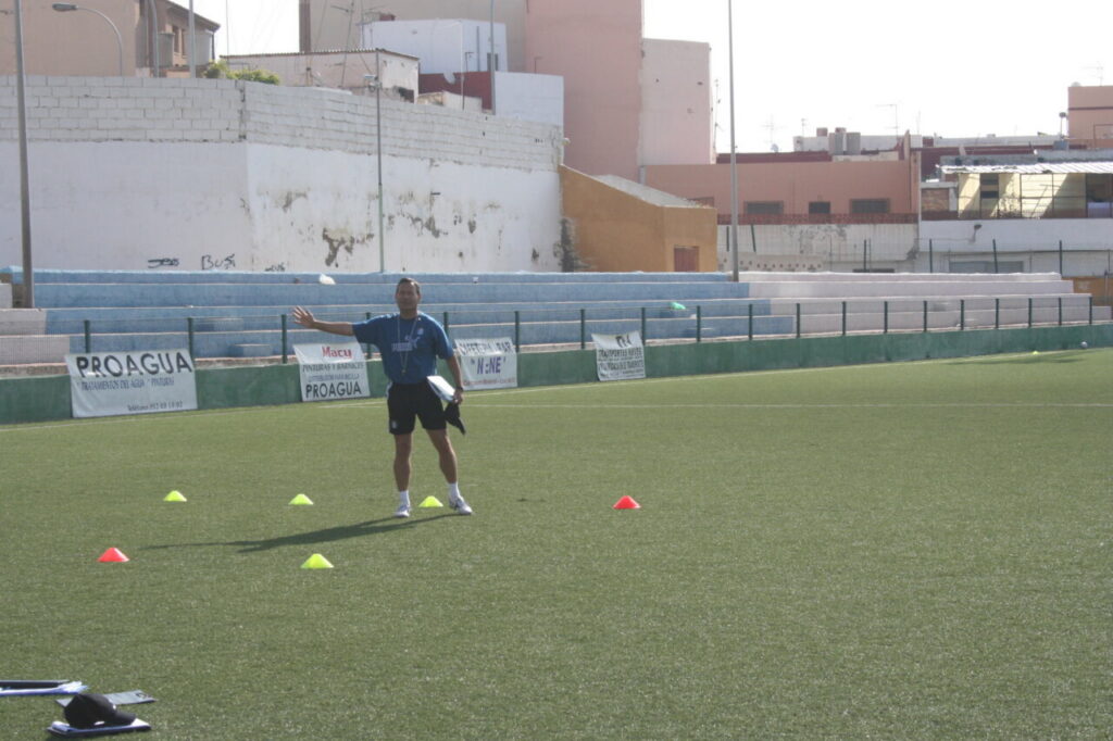 Entrenador de fútbol dirigiendo una sesión en el campo