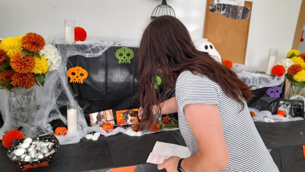 Persona preparando altar en homenaje a mascotas fallecidas