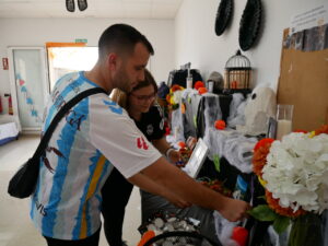 Pareja interactuando con altar en homenaje a mascotas fallecidas