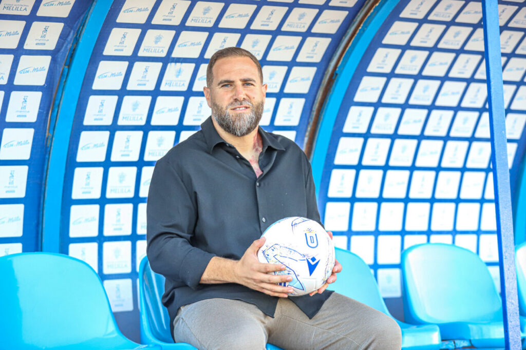 Javi Motos posando como nuevo entrenador de la U.D. Melilla con un balón.