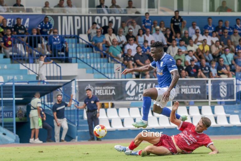 Jugador de la U.D. Melilla en acción durante un partido de fútbol.