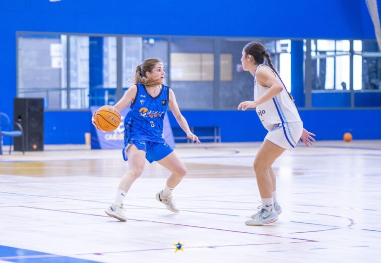 Jugadora driblando con balón en un partido de baloncesto