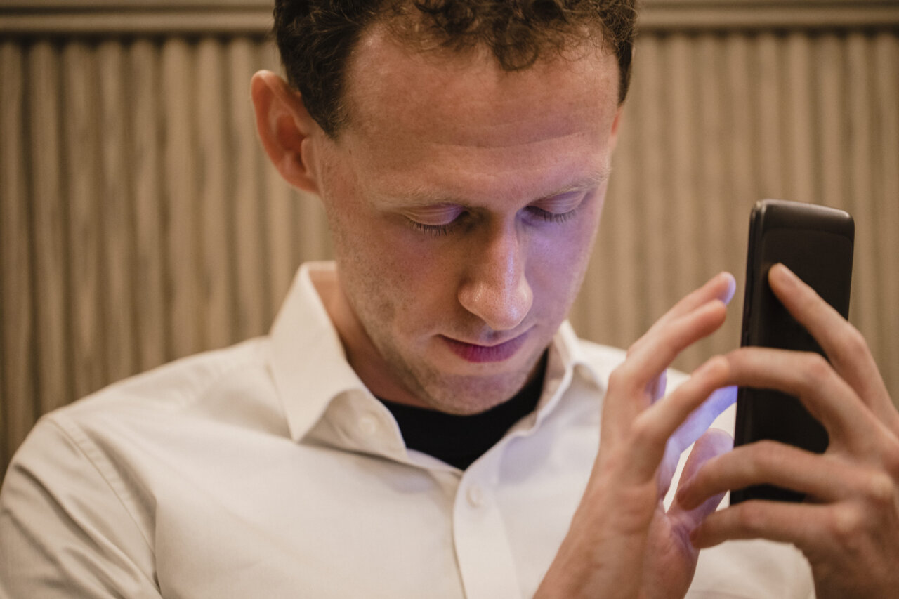Hombre usando un teléfono móvil en un entorno moderno.
