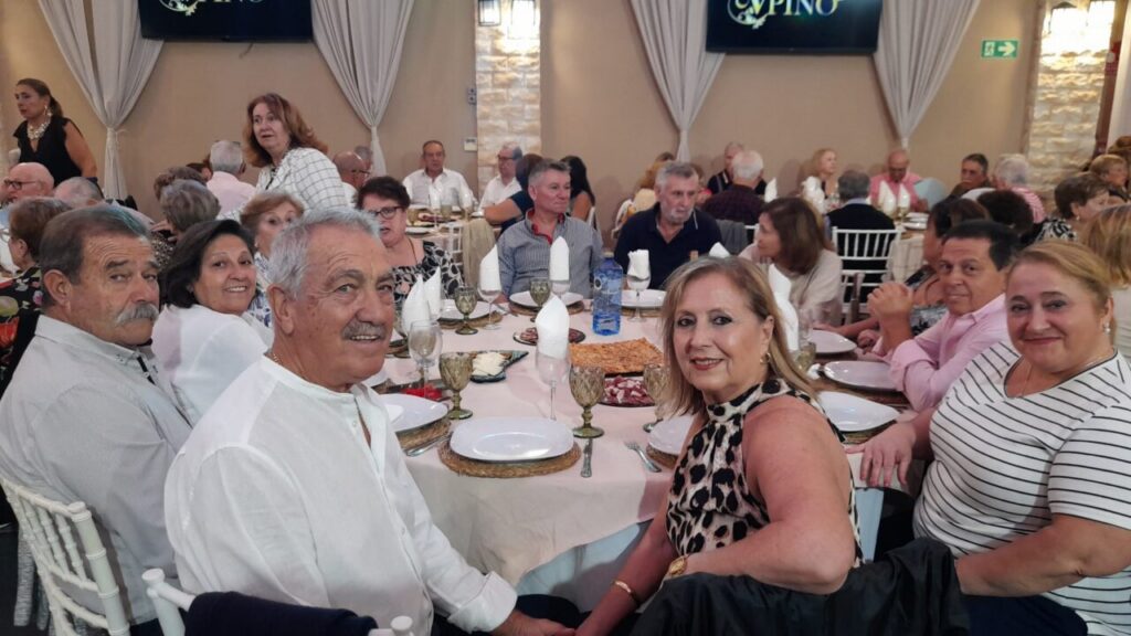 Grupo de mayores disfrutando de una merienda en un evento social.