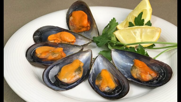 Mejillones cocidos con limón y ajo en un plato blanco