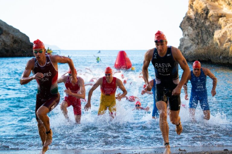 Jóvenes triatletas compitiendo en el agua durante un triatlón en Melilla