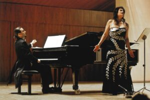 Ana Häsler cantando en un recital acompañada por un pianista