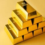 Lingotes de oro apilados sobre fondo amarillo