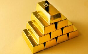 Lingotes de oro apilados sobre fondo amarillo