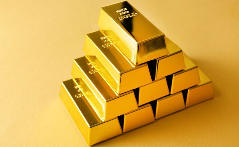 Lingotes de oro apilados sobre fondo amarillo