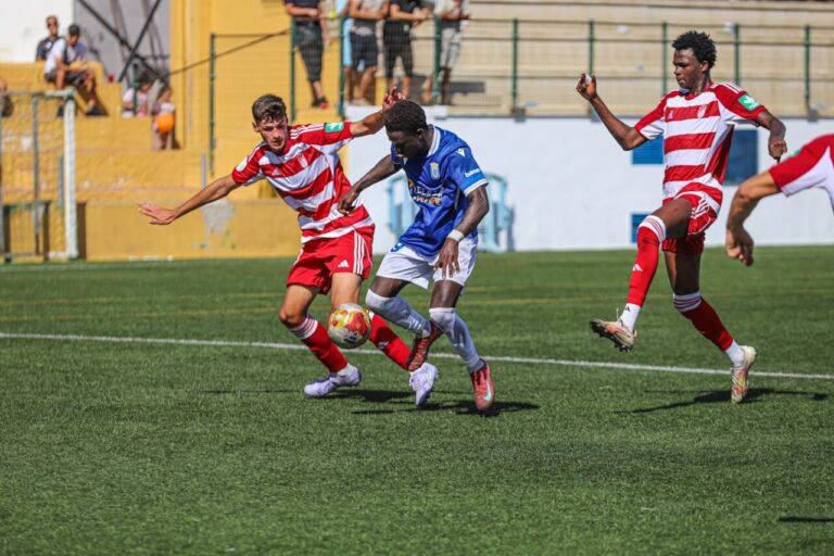 Jugadores de fútbol compitiendo en un partido entre U.D. Melilla y U.D. San Pedro.