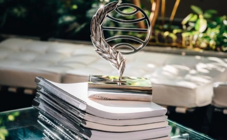 Trofeo del Premio Planeta 2025 sobre una pila de libros.