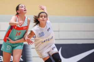 Dos niñas compitiendo en un partido de minibasket en el pabellón