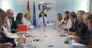 Reunión del Partido Popular con varios miembros en una mesa