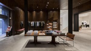 Interior de una tienda de moda con muebles de madera y ropa exhibida