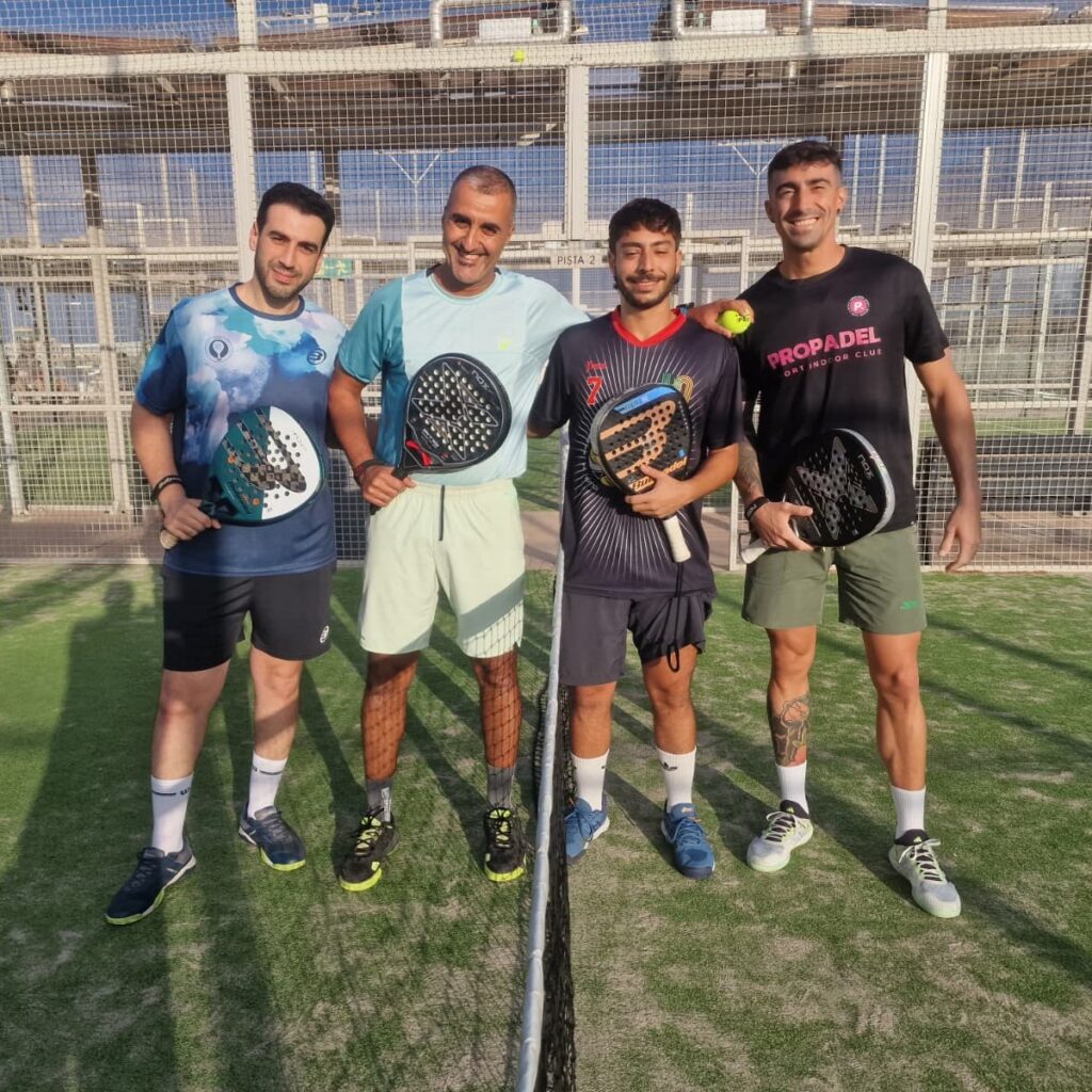 Cuatro jugadores de pádel posando con palas en el torneo solidario.