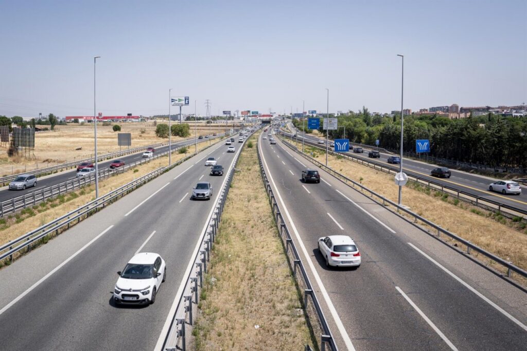 Vista de carretera con vehículos en movimiento y señalización