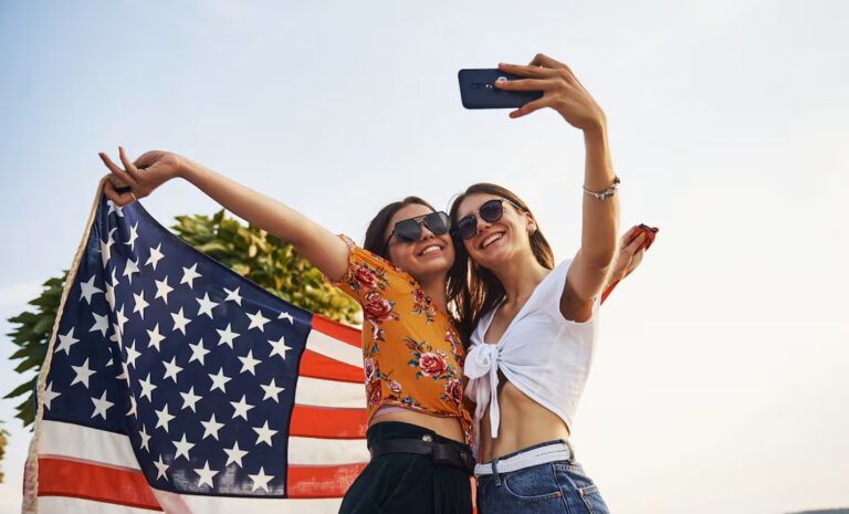 Dos turistas estadounidenses posando con una bandera de EE.UU.
