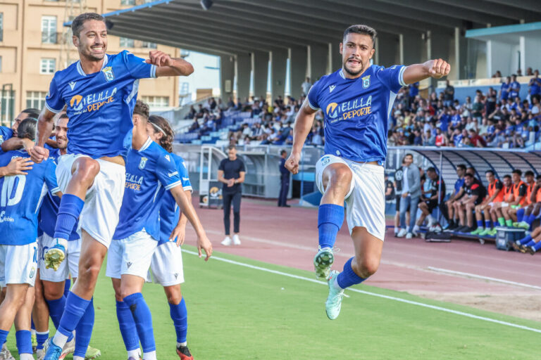 Jugadores de la U.D. Melilla celebrando un gol en el campo.