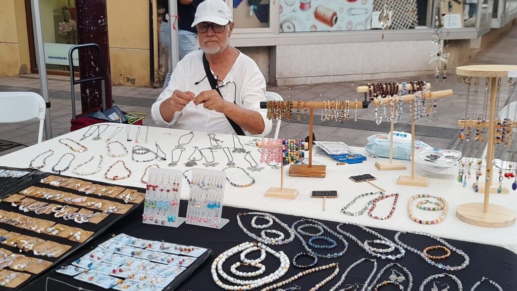 Hombre creando joyas en un puesto de la verbena popular en Melilla