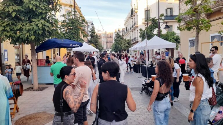 Gente disfrutando de una verbena popular en Melilla con juegos y música.