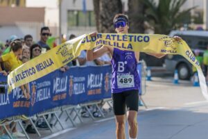 Atleta cruzando la meta en la Carrera contra el Cáncer en Melilla