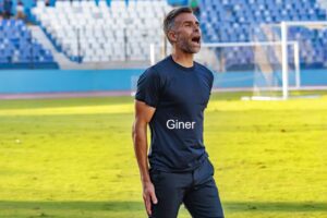 Entrenador de la U.D. Melilla celebrando una victoria en el campo.