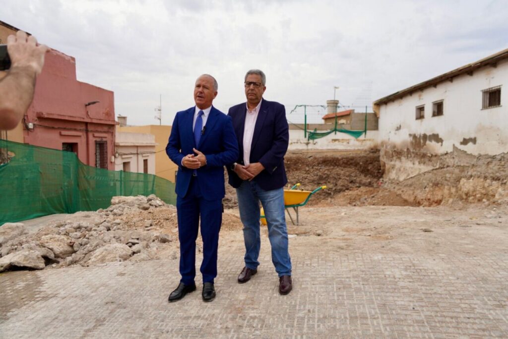 Dos hombres en un terreno donde se construyen viviendas de protección oficial en Melilla.