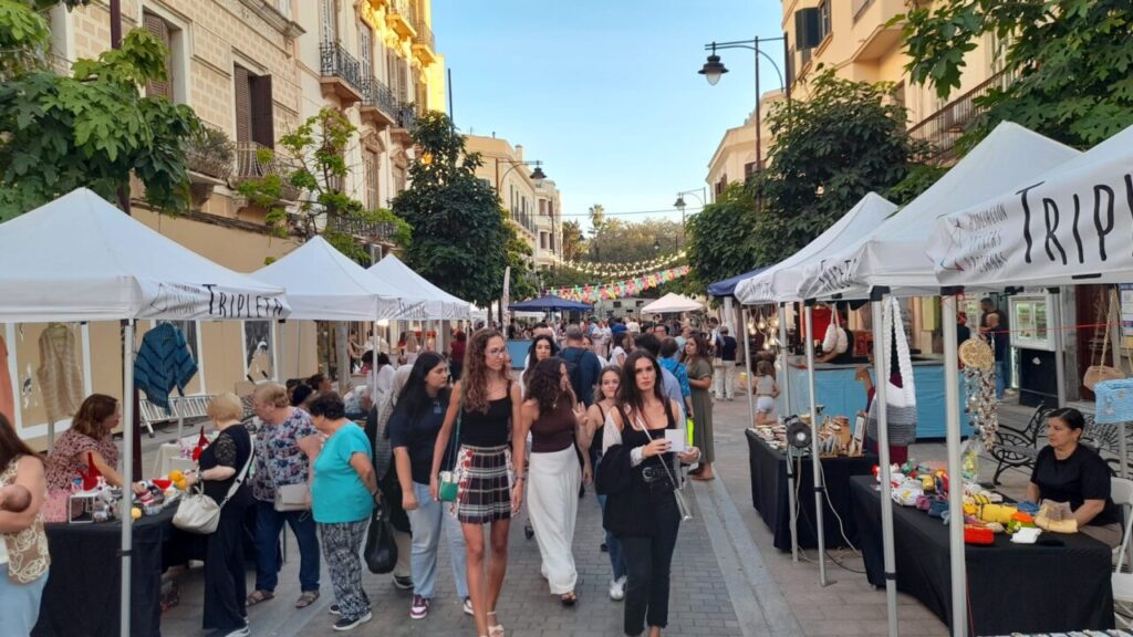 Multitud disfrutando de una verbena popular en Melilla con puestos y actividades.