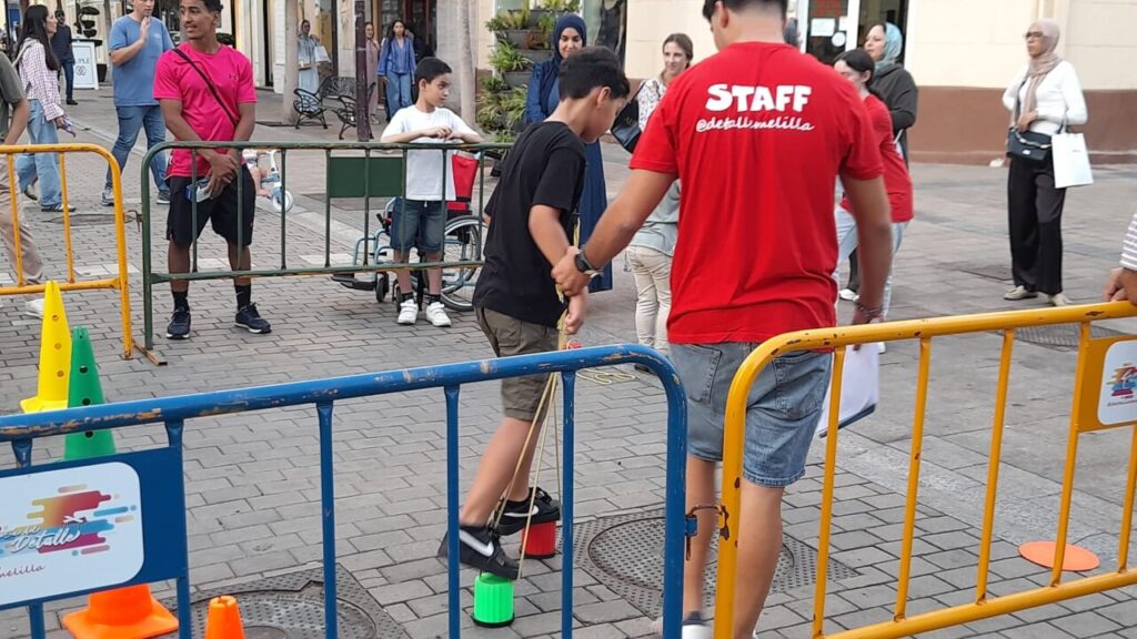 Niños y adultos disfrutando de juegos en la verbena popular de Melilla