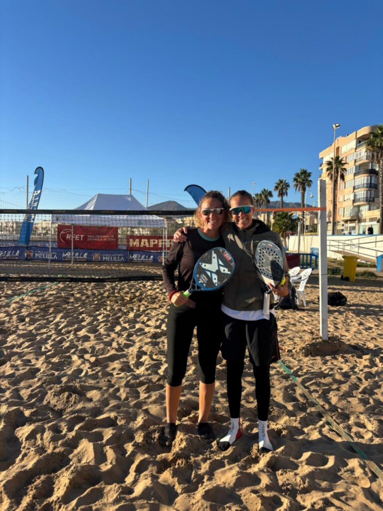 María Martínez y Nicolás Volpe posando con trofeos en la playa