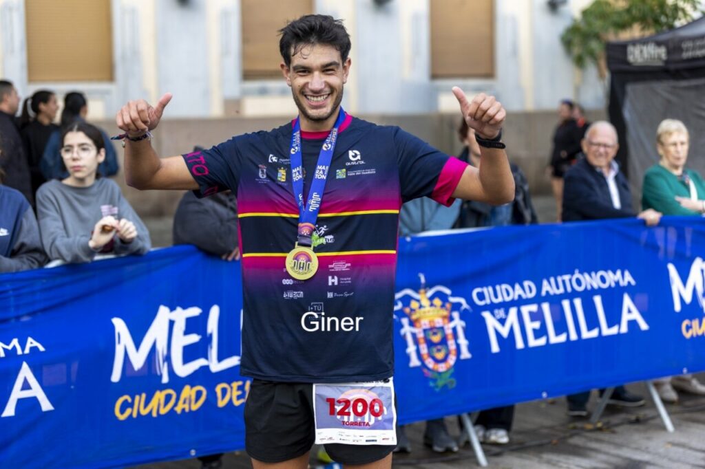 Atleta celebrando con medalla en la Media Maratón de Melilla